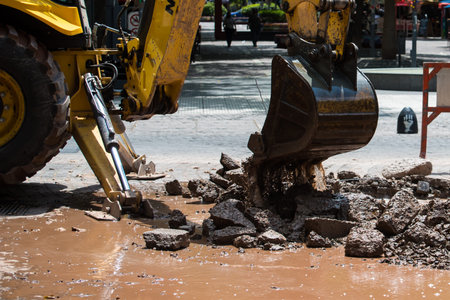 bulldozer shovel lifting debris strewn over the street