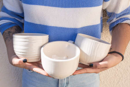 hand holding handmade ceramic cupsの写真素材