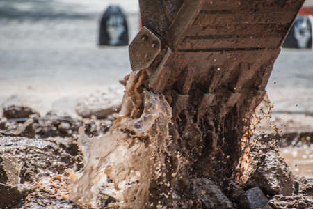 bulldozer shovel lifting mud and water from the streetsの写真素材