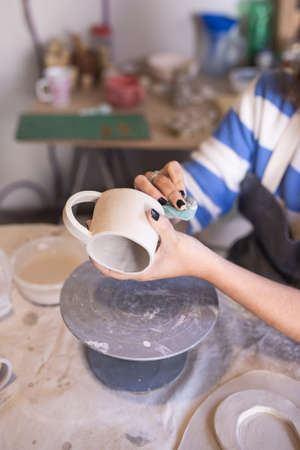 woman working a handmade ceramic cup in her workshopの写真素材