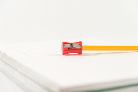 pencil and sharpener on a blank notebook on a table