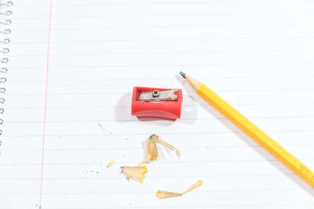 pencil and pencil sharpener on a dirty sheet of paperの写真素材
