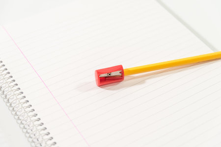 pencil and sharpener on a blank notebook on a table