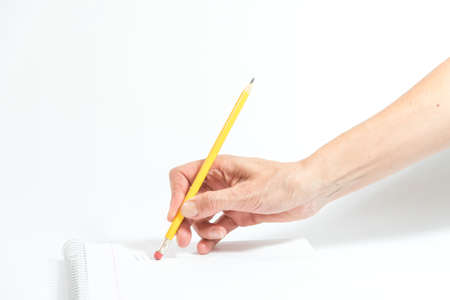 hand erasing with the rubber of a pencil a sheet of a notebookの写真素材