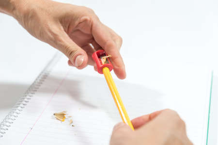 hand sharpening a pencil with a sharpenerの写真素材
