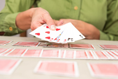 person with cards shuffled in hand and on the table