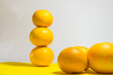 yellow grapefruits placed artistically on a yellow tableの写真素材