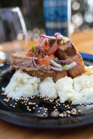 dish with meat, mashed potatoes and vegetables, glass and beer on the tableの写真素材