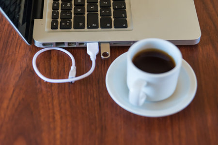 laptop and coffee cup on a wooden table