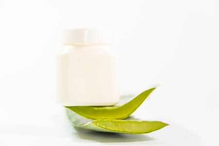 fresh Aloe Vera leaves next to plastic container on a tableの写真素材
