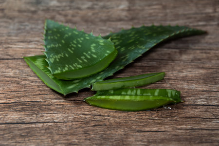 pieces of fresh Aloe Vera leaves on a wooden tableの写真素材