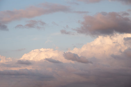 Beautiful sky background. Light blue sky with dramatic orang, pink, and gray clouds.