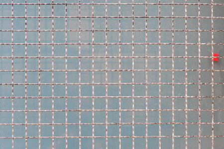 Metal grid on a concrete block backgroundの写真素材