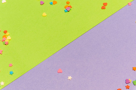 Small colorful candies, Heart and star shapes, on a green and purple background. Valentine day....