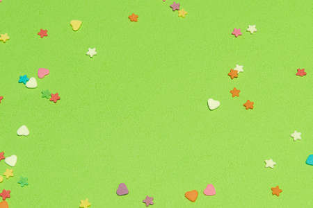 Small colorful candies, Heart and star shapes, on a green background. Valentine day. About love. copy space.の写真素材