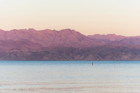 Sunset over the Red sea with pink orange mountains on the background. Eilat, Aqaba, Israel, Jordan