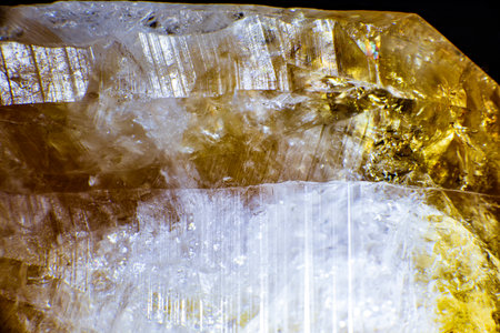 macro shooting of natural rock specimen. Raw crystal of Citrine yellow quartz gemstone from Brazil. Shimmering gold backgroundの写真素材