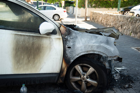 Jaffa, Tel Aviv, Israel. Burned car close up. Car after the fire, crime of vandalism, riots. Arson car. Accident on the road due to speeding. Explosion. Car accidentのeditorial素材