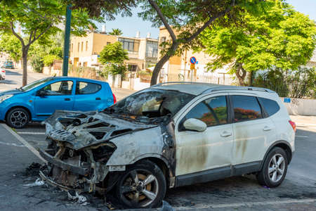 Jaffa, Tel Aviv, Israel. Burned car close up. Car after the fire, crime of vandalism, riots. Arson car. Accident on the road due to speeding. Explosion. Car accidentのeditorial素材