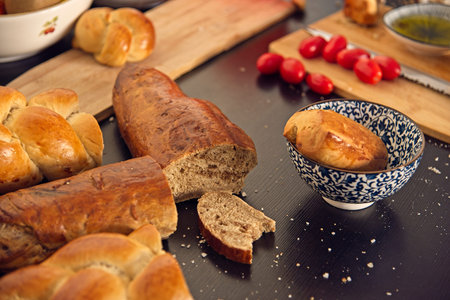 Feast, messy table. Bread in the shape of a braid. Sweet Challah. breakfast, side view. Cherry...