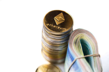 Roll Israeli Shekel ILS banknotes near cryptocurrency tokens Ethereum eth, saw from above, on white background. Selective focus. with space for text placement. Isolatedのeditorial素材