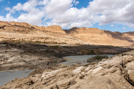 Sinkhole filled with turquoise water, near Dead Sea coastline. Hole formed when underground salt is dissolved by freshwater intrusion, due to continuing sea-level drop.の写真素材