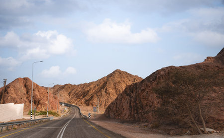A road next to a mountainous desert landscape. Road 12 on the way to Eilat, Israel, on the Egyptian...