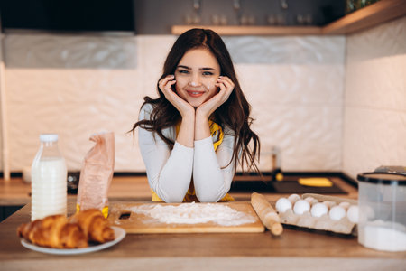 Young housewife cooking pie cookies cake. Pretty woman is baking in the kitchen.の写真素材