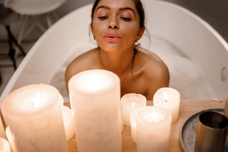 Close up young and calm woman relaxing in the beautiful vintage bath full of foam in the retro...