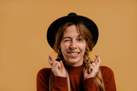 Photo of cute female farmer looks nervous and worries so cross fingers . White woman wears denim...