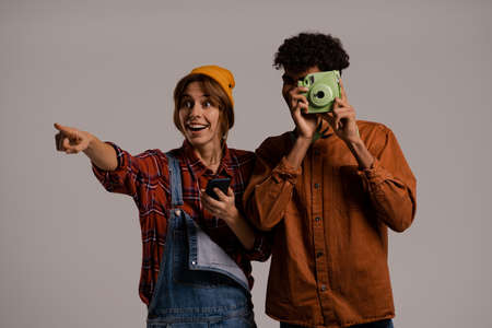 Photo of cute couple farmers take a photo on and looks happy together . White woman wears denim overall, black man shirt isolated grey color backgroundの写真素材