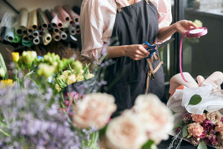 Close up photo florist at work. woman making spring floral decorations.の写真素材