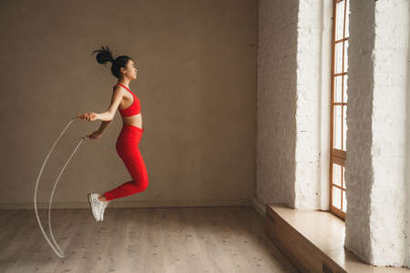 Woman is jumping rope, workout at health club. Sporty attractive female working out. Healthy lifestyleの写真素材
