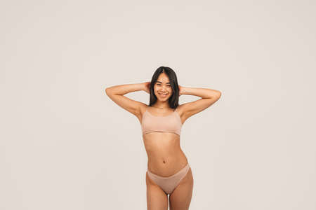 Photo of natural woman face, wears underwear. Isolated over white background. Natural beauty and health. Clean skin and cute smileの写真素材