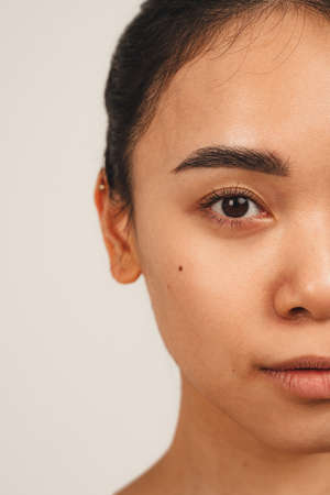 Portrait of half of face natural cute woman. Isolated over white background. Natural beauty and healthの写真素材