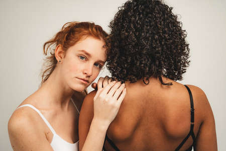 Photo of natural multiracial women, body positive. Feminist females in underwear hug and feel support, isolated on white background. Concept natural beauty and girl power.の写真素材