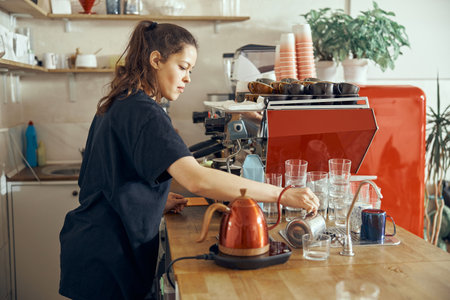 Barista giving order to client at the trendy coffee shop. Pouring water in glassの写真素材