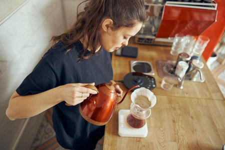 Barista female is making delicious, freshly ground morning coffee powder in the coffee filterの写真素材