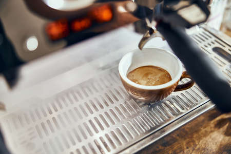 Close-up of espresso pouring from coffee machine. Professional coffee brewing.の写真素材