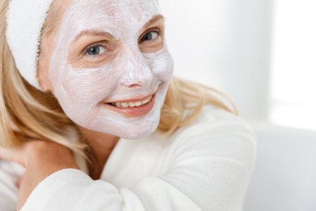Close up of senior woman with nutrition mask on her face, visiting cosmetologists in modern medical centerの写真素材
