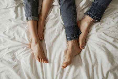 Close up legs of young couple in bad wearing jeansの写真素材