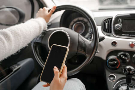 Woman use mobile phone in personal autoの写真素材