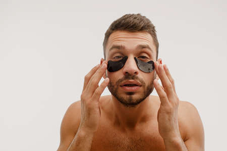 Focused young man with under eye patch on faceの写真素材