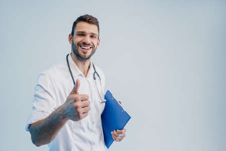 Smiling male doctor showing thumb up gestureの写真素材