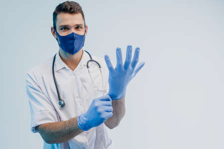 European male doctor putting latex gloves onの写真素材