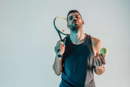 Confident tennis player hold ball and racquetの写真素材