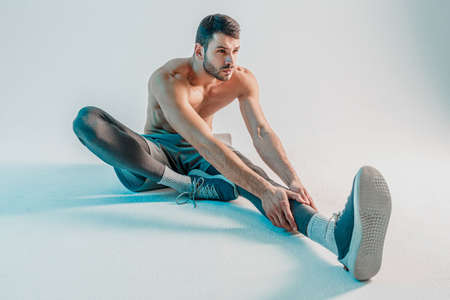 Sportsman stretching leg before training in studioの写真素材