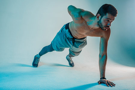 Young european sportsman doing plank in studioの写真素材