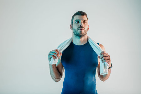 Young european sportsman with towel in studio