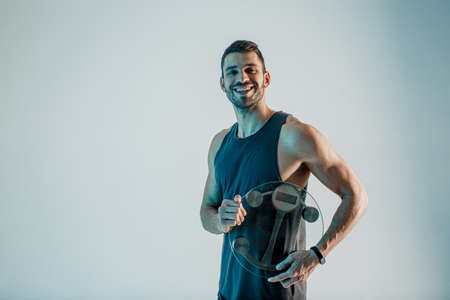 Cheerful sportsman hold weight scales in studioの写真素材